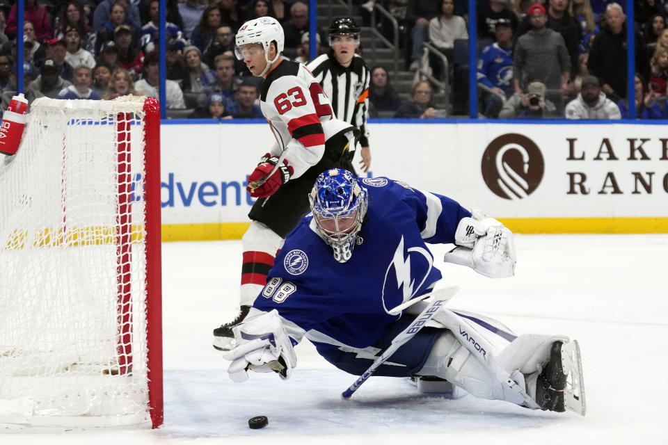 Tampa Bay Lightning goaltender Andrei Vasilevskiy (88) makes a save on a shot by New Jersey Devils left wing Jesper Bratt (63) during the third period of an NHL hockey game Thursday, Jan. 11, 2024, in Tampa, Fla. (AP Photo/Chris O'Meara)