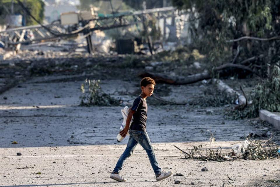 A young boy walks past felled trees and destroyed structures in Gaza City on Thursday (AFP/Getty)