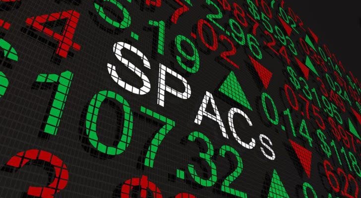 A 3D illustration of the word SPACs on a stock board full of numbers and up and down arrows.