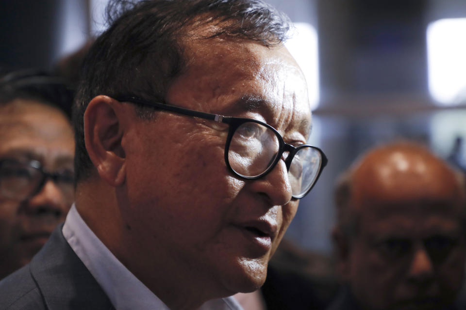 FILE - In this Nov. 9, 2019, file photo, Cambodia's exiled opposition leader Sam Rainsy talks with the media upon arrival at Kuala Lumpur International Airport in Sepang, Malaysia, in a bid to return to his homeland after Thailand had earlier blocked him from entering. Phnom Penh Municipal Court has convicted and sentenced the exiled leader and senior members of the country's banned opposition party to more than 20 years in prison, effectively barring them from ever returning home. The decision taken by the court late Monday, March 1, 2021 was condemned by the head of the Cambodia National Rescue Party , or CNRP, human rights organizations and the United States embassy. The trial was held in absentia as all the party leaders are living abroad. (AP Photo/Vincent Thian, File)