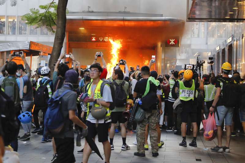 反送中示威者8日在中環地鐵站外放火。（美聯社）