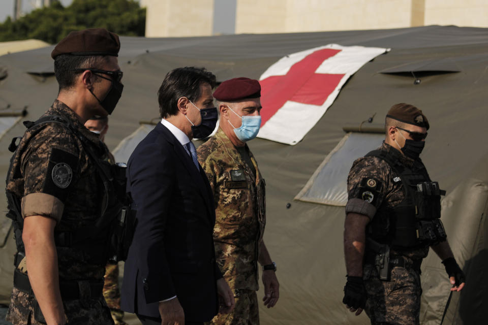 Italian Prime Minister Giuseppe Conte, second left, visits an Italian field hospital set up at the Lebanese University in the Hadath district of Beirut, Lebanon, Tuesday, Sept. 8, 2020. Conte said Tuesday his country will support Lebanon's economic and social growth, expressing hopes that a new government is formed quickly — one that would start the reconstruction process in the wake of last month's Beirut explosion and implement badly needed reforms. (AP Photo/Hassan Ammar)