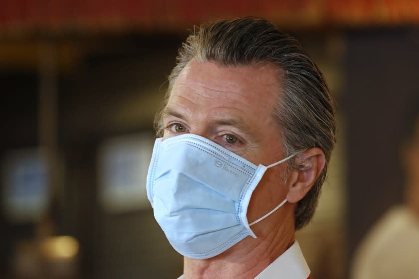 California Gov. Gavin Newsom, wears a face mask as he answers a reporter's question during his visit to the Queen Sheba Ethiopian Cuisine restaurant, in Sacramento, Calif., Friday, June 19, 2020. Newsom visited the restaurant that is participating in the Great Plates Delivered program that provides meals to older adults who are at-risk to COVID-19. (AP Photo/Rich Pedroncelli, Pool)