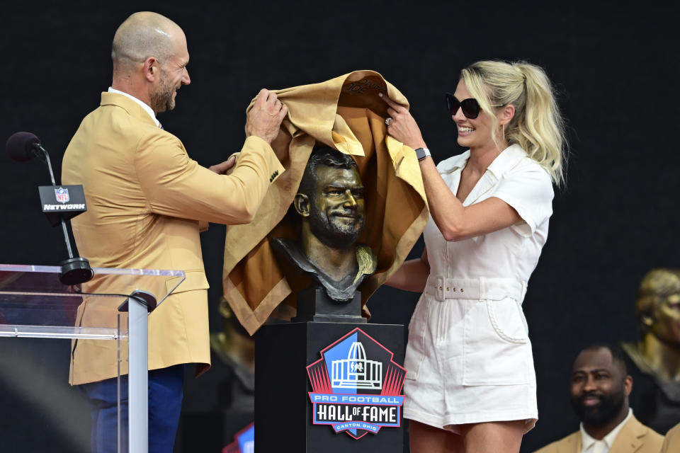 Former NFL player Joe Thomas, left, and his wife Annie unveil his bust during his induction into the Pro Football Hall of Fame in Canton, Ohio, Saturday, Aug. 5, 2023. (AP Photo/David Deemer)