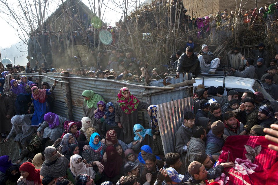 Kashmiri villagers watch as vehicle carrying the body of a local rebel Muzamil Ahmed Dar arrives at his residence in Rahmoo village south of Srinagar, Indian controlled Kashmir, Saturday, Dec. 29, 2018. Anti-India protests and clashes erupted in disputed Kashmir on Saturday after a gunbattle between militants and government forces killed four rebels, police and residents said. (AP Photo/ Dar Yasin)