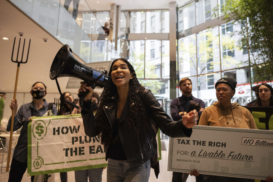 ARCHIVO - Una activista climática habla mientras ella y otras personas bloquean una escalera mecánica en la sede en Nueva York de BlackRock, durante una protesta de OccupyParkAve, el 26 de octubre de 2022, en Nueva York. La generación del cambio climático afirma que los gobernantes hablan demasiado, no escuchan suficiente y actúan aún menos. Y están hartos. (AP Foto/Yuki Iwamura, Archivo)