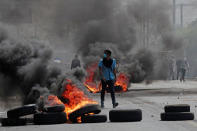 A demonstrator walks past burning tyres during a protest over a controversial reform to the pension plans of the Nicaraguan Social Security Institute (INSS) in Managua, Nicaragua April 20, 2018. REUTERS/Oswaldo Rivas