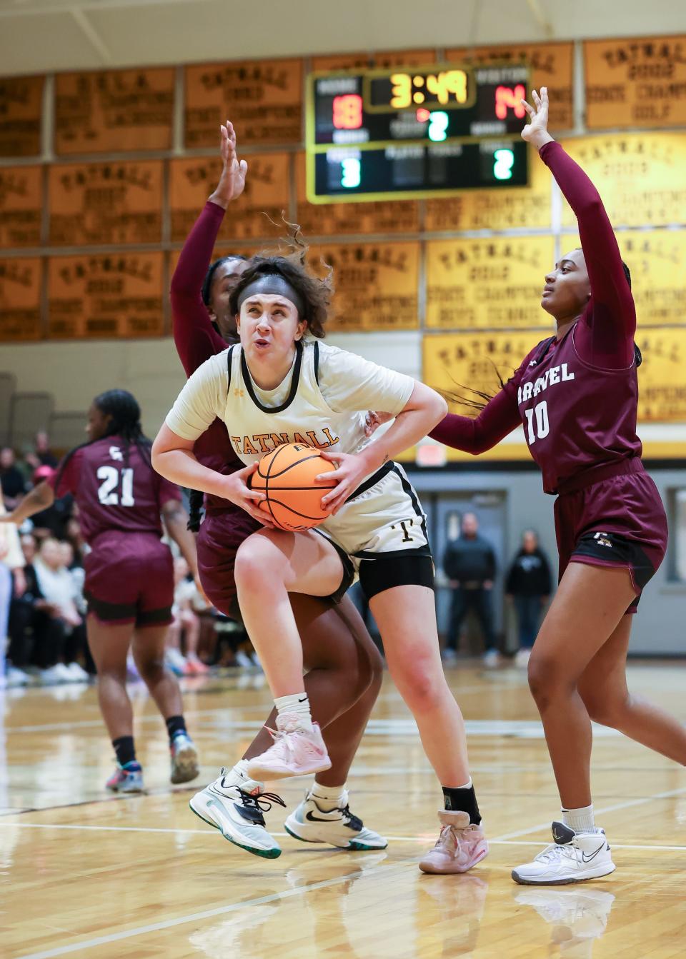 Tatnall senior Emma Kirby steps through two Caravel defenders for a shot attempt during the Buccaneers 57-54 win over the Hornets in a quarterfinal girls basketball matchup on March 6, 2023.