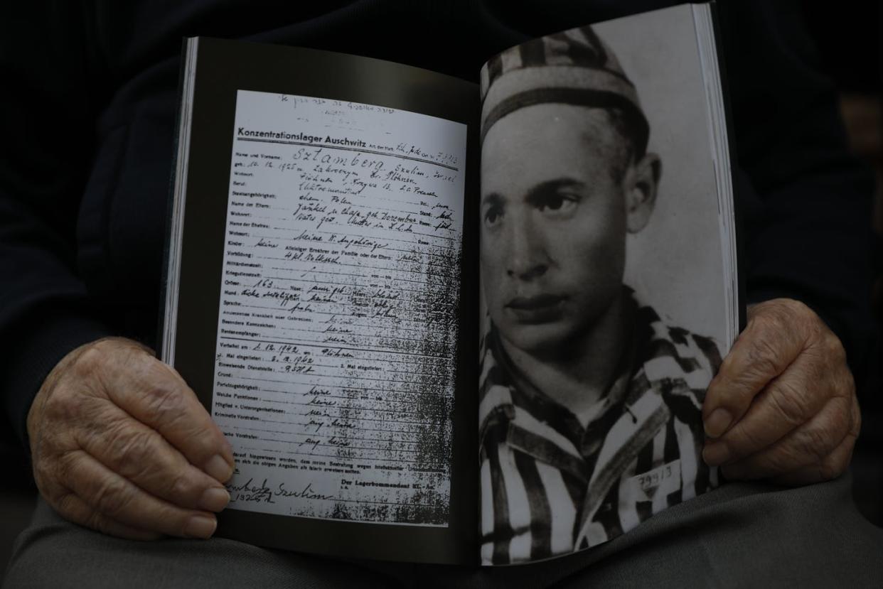 <span class="caption">Holocaust survivor Shalom Stamberg holds a book with a photo of himself in Auschwitz, alongside a copy of his concentration camp record.</span> <span class="attribution"><a class="link " href="https://newsroom.ap.org/detail/VirusOutbreakIsraelHolocaust/e78d176de34f46bf8313df761859140b/photo" rel="nofollow noopener" target="_blank" data-ylk="slk:AP Photo/Ariel Schalit;elm:context_link;itc:0;sec:content-canvas">AP Photo/Ariel Schalit</a></span>