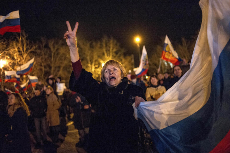 Pro-Russian people celebrate in the central square in Sevastopol, Ukraine, late Sunday, March 16, 2014. Russian flags fluttered above jubilant crowds Sunday after residents in Crimea voted overwhelmingly to secede from Ukraine and join Russia. The United States and Europe condemned the ballot as illegal and destabilizing and were expected to slap sanctions against Russia for it.(AP Photo/Andrew Lubimov)