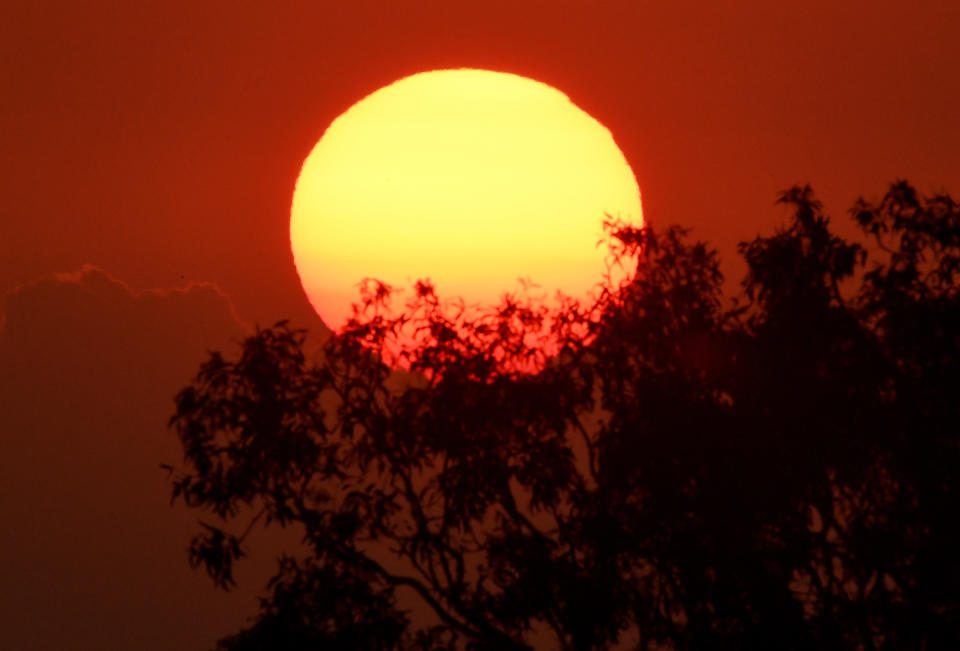 The sun is seen rising, illuminating the sky red. Source: AAP