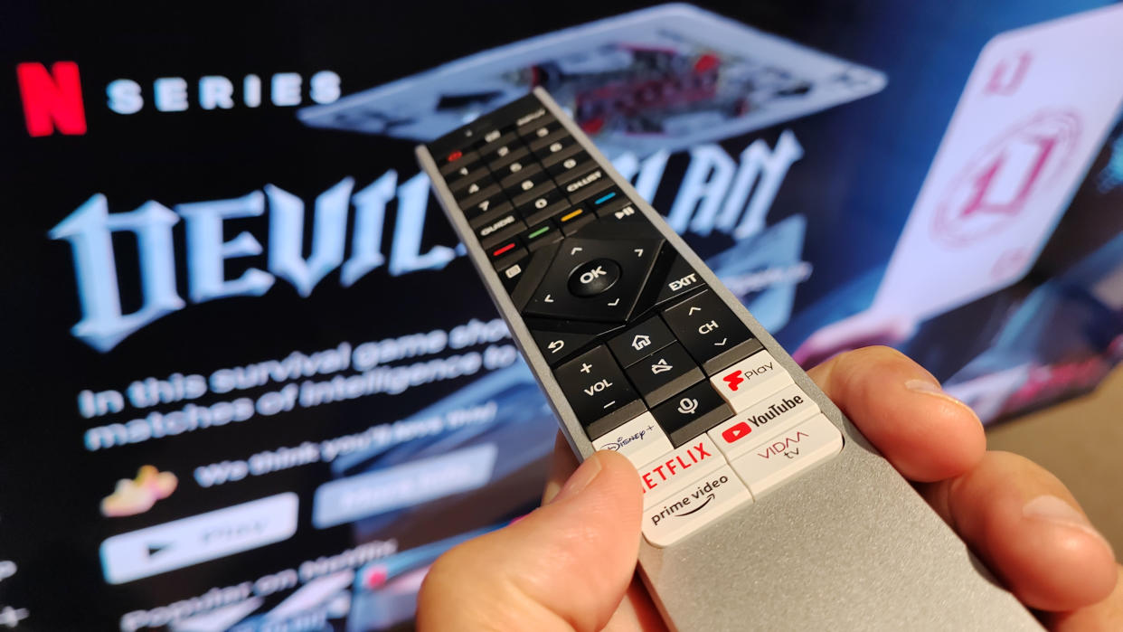  Remote control pointing at a TV with Netflix on the screen. 