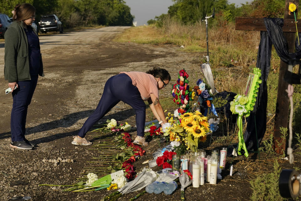 Mourners pay their respects at a makeshift memorial at the site where officials found dozens of people dead in an abandoned semitrailer containing suspected migrants, Wednesday, June 29, 2022, in San Antonio. (AP Photo/Eric Gay)