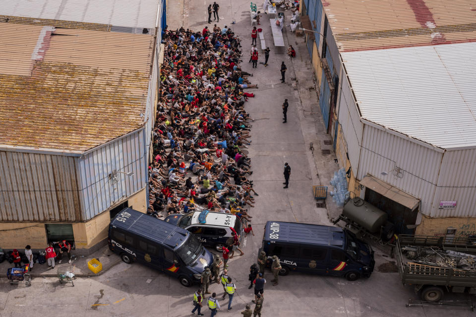 Unaccompanied minors who crossed into Spain are gathered outside a warehouse used as temporary shelter as they wait to be tested for COVID-19 at the Spanish enclave of Ceuta, near the border of Morocco and Spain, Wednesday, May 19, 2021. Social services for the small city perched on an outcropping in the Mediterranean buckled under the strain after more than 8,000 people crossed into Spanish territory during the previous two days. (AP Photo/Bernat Armangue)