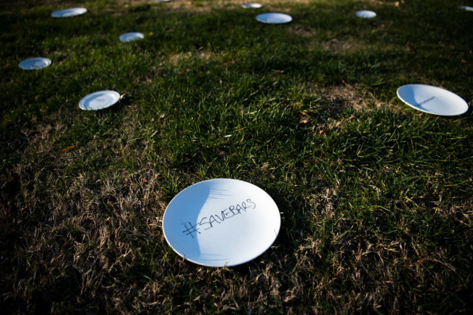 Plates marked with the names and stories of restaurant workers scatter the East Lawn of the Capitol in Washington. 