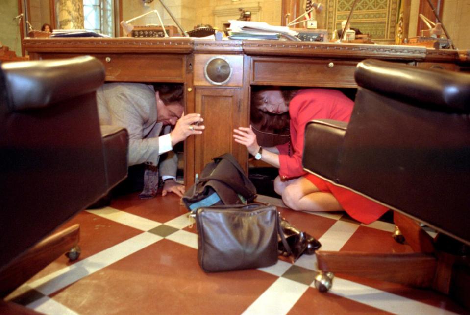 LA city council members take cover under their desks during a short earthquake preparedness drill.