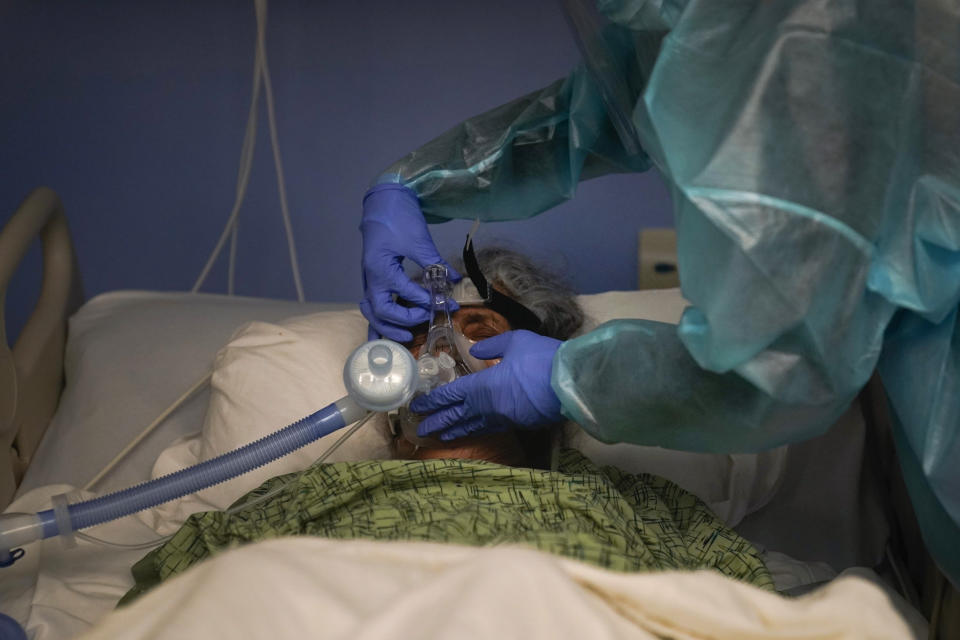 Registered nurse Kyanna Barboza adjusts the ventilator on her COVID-19 patient at St. Joseph Hospital in Orange, Calif., Thursday, Jan. 7, 2021. California health authorities reported Thursday a record two-day total of 1,042 coronavirus deaths as many hospitals strain under unprecedented caseloads. (AP Photo/Jae C. Hong)