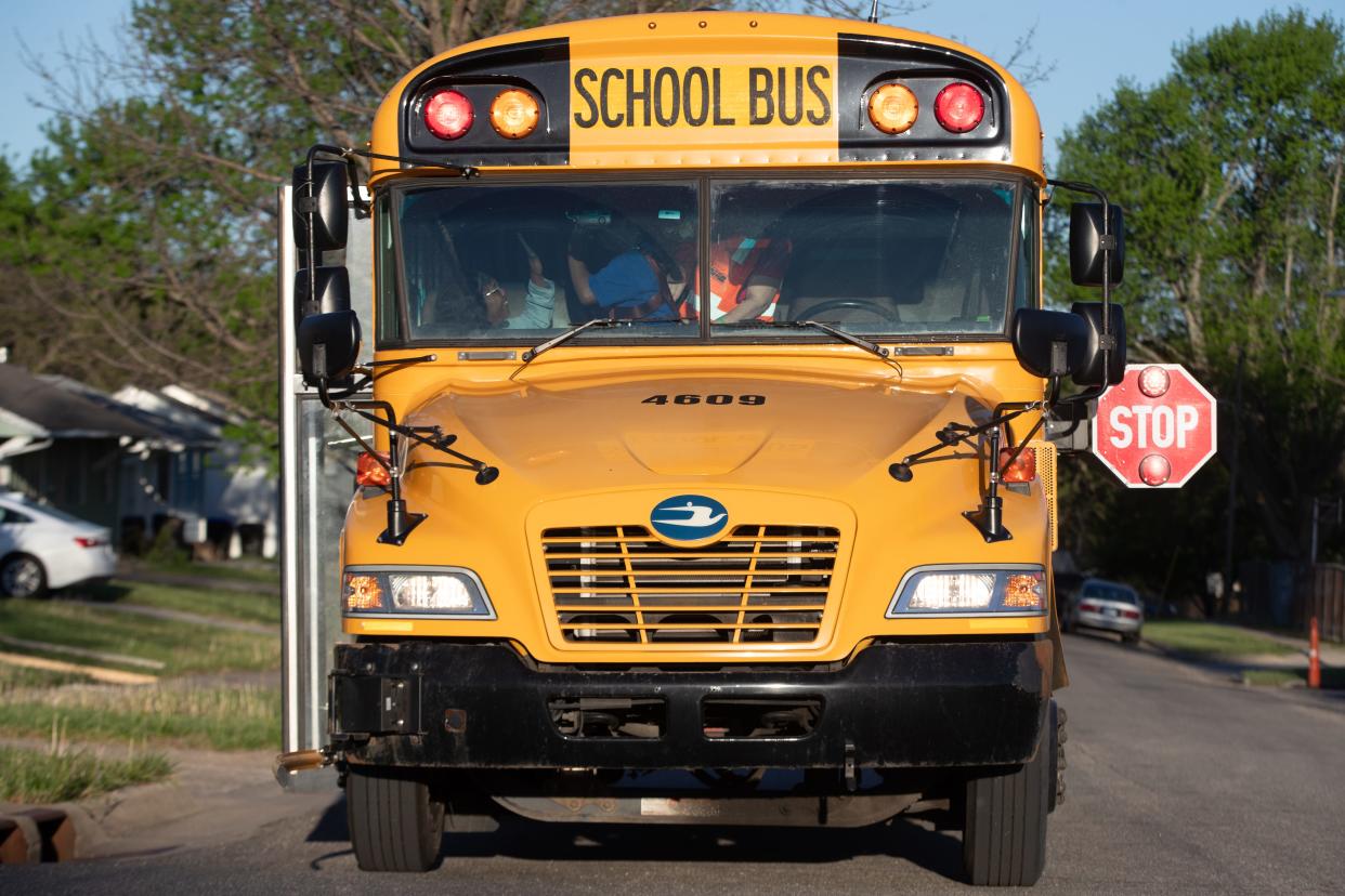 Zytaya Bush, left, gives her son, 11-year-old son Zae Morgan-Bush a high-five Wednesday morning after he got onto the school bus heading to State Street Elementary at the intersection of S.E. 40th and Quincy streets.