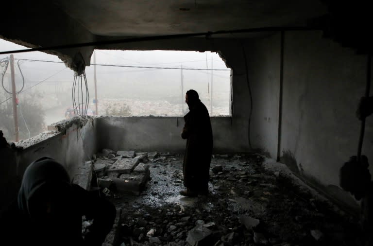 An onlooker inspects the remains of the apartment of a Palestinian accused of the fatal September stabbing of an Israeli-American after it was demolished by the Israeli army