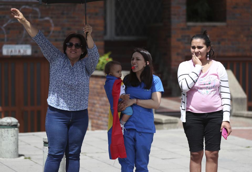 Three women show their support for an anti-government march in Bogota, Colombia, Wednesday, Dec. 4, 2019. Colombia’s recent wave of demonstrations began with a massive strike on Nov. 21 that drew an estimated 250,000 people to the streets. Protests have continued in the days since but at a much smaller scale. (AP Photo/Fernando Vergara)