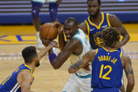 Charlotte Hornets center Bismack Biyombo, center, is defended by Golden State Warriors guard Stephen Curry, left, forward Andrew Wiggins, top, and guard Kelly Oubre Jr. (12) during the first half of an NBA basketball game in San Francisco, Friday, Feb. 26, 2021. (AP Photo/Jeff Chiu)