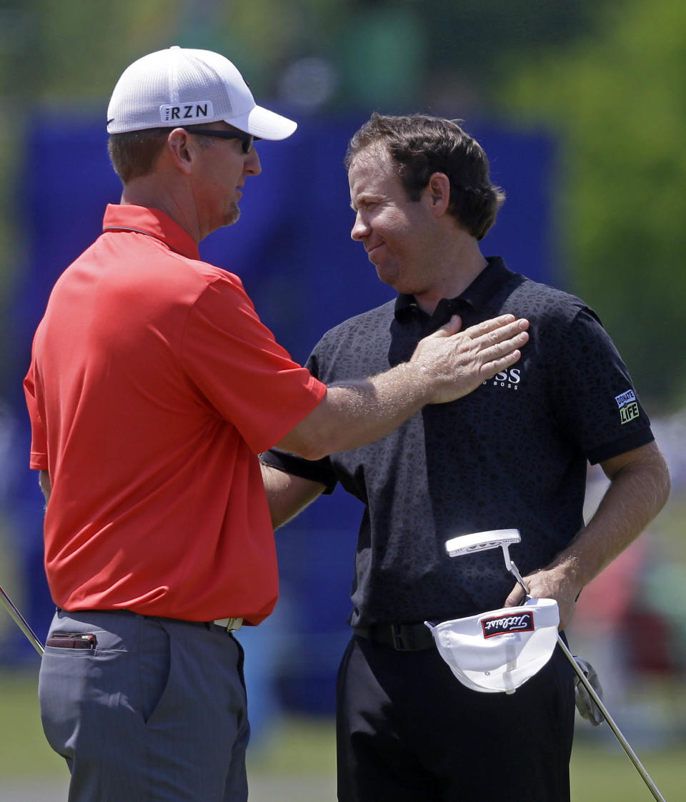 Erik Compton, right, is congratulated by David Duval after the two finished the day on the ninth green during the opening round of the Zurich Classic golf tournament at TPC Louisiana in Avondale, La., Thursday, April 24, 2014. Compton finished six under par and Duval finished 4 under. (AP Photo/Gerald Herbert)