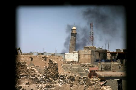 Al-Hadba minaret at the Grand Mosque is seen through a building window in the old city of Mosul, Iraq June 1, 2017. REUTERS/Alaa Al-Marjani
