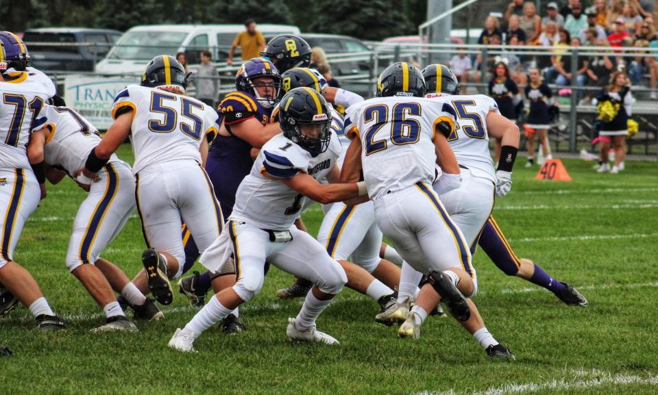 Whiteford quarterback Tre Eitniear hands off to Jake Iott during a 28-21 victory over Blissfield Friday night.