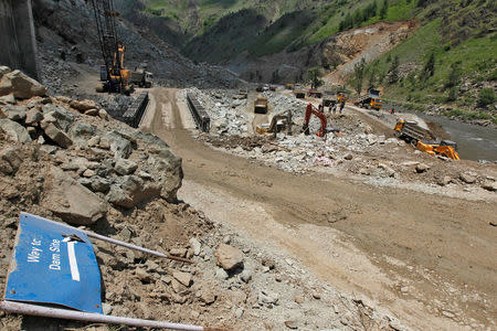 FILE PHOTO: Work is being done beside a signboard lying at the dam site of Kishanganga power project in Gurez, 160 km (99 miles) north of Srinagar June 21, 2012. REUTERS/Fayaz Kabli/File Photo