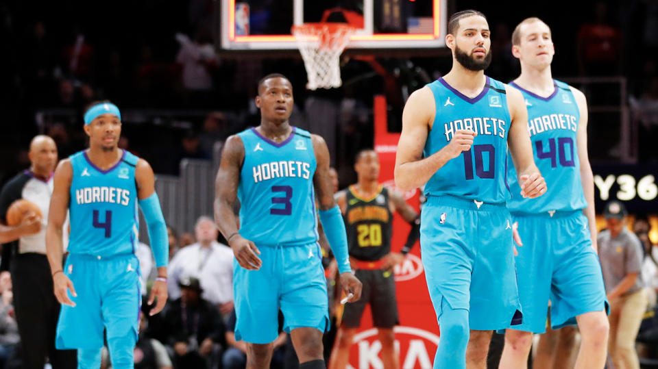 Charlotte Hornets players walking off the court.