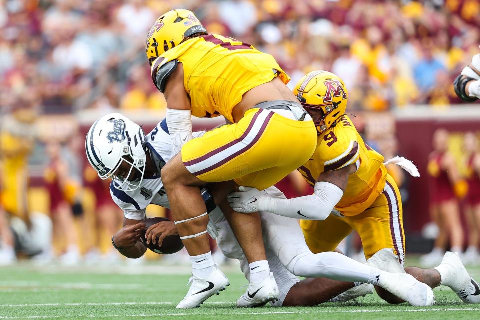 Minnesota Golden Gophers linebacker Devon Williams (9) and defensive lineman Anthony Smith (0) tackle Nevada Wolf Pack quarterback Brendon Lewis (2) during the second half at Huntington Bank Stadium on Saturday in Minneapolis.