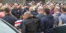 Officers line the path four deep as the body of a slain Champaign, Ill., police officer Christopher Oberheim is taken into the coroner's office Wednesday, May 19, 2021, in Urbana, Ill. Authorities say a gunman killed one central Illinois police officer and wounded another before he was fatally shot during a shootout at an apartment complex. (Robin Scholz/The News-Gazette via AP)