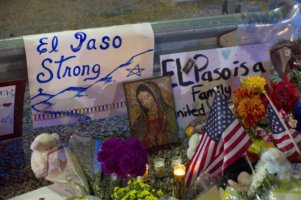 FILE - In this Aug. 4, 2019 file photo, a Virgin Mary painting, flags and flowers adorn a makeshift memorial for the victims of the mass shooting at a Walmart in El Paso, Texas. A man whose 63-year-old wife was among the Texas mass shooting victims says he has no other family and welcomes anyone wanting to attend her services in El Paso. Margie Reckard was among 22 people fatally shot on Aug. 3 at a the Walmart. Reckard and Antonio Basco were married 22 years. (AP Photo/Andres Leighton, File)