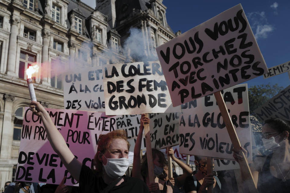 Women's rights activists protest against French President Emmanuel Macron's appointment of an interior minister who has been accused of rape and a justice minister who has criticized the #MeToo movement, in front of Paris city hall, in Paris, France, Friday, July 10, 2020. The French government said it remains committed to gender equality and defended the new ministers, stressing the presumption of innocence. Gerald Darmanin, Interior Minister, firmly denies the rape accusation, and an investigation is underway. New Justice Minister Eric Dupond-Moretti is a lawyer who has defended a government member accused of rape and sexual assault, and has ridiculed women speaking out thanks to the #MeToo movement. (AP Photo/Francois Mori)