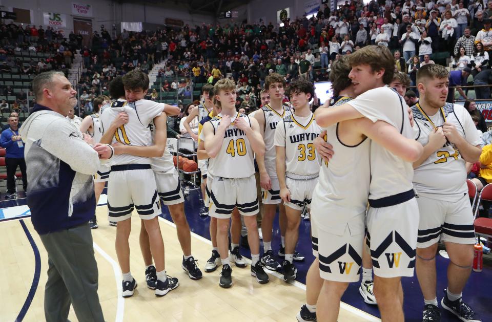 Wayne basketball players console each other after they were defeated by Glens Falls 50-37 in the state championship game at the Cool Insuring Arena in Glens Falls, New York March 16, 2024.