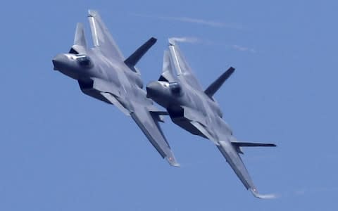  Caption: Two J-20 stealth fighter jets perform during the 12th China International Aviation and Aerospace Exhibition, also known as Airshow China 2018, in Zhuhai city Description: - Credit: Kin Cheung/AP