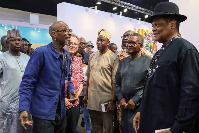 Exhibiting artist, Abe Odedina, shows his artwork to Nigerian billionaire Aliko Dangote in Lagos