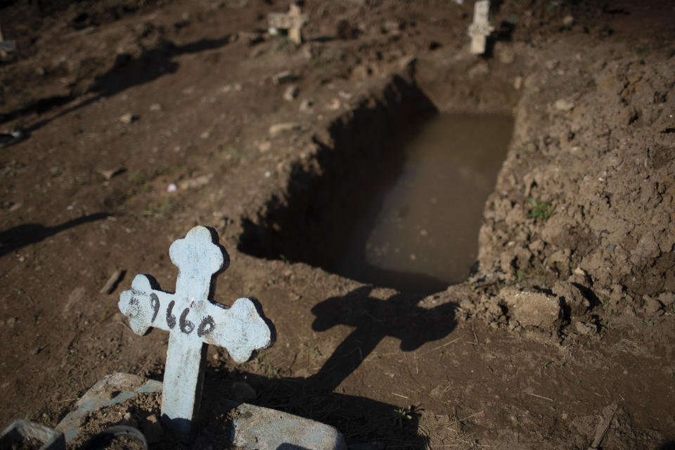 A cross with a number marks an empty grave at the Caju cemetery where many COVID-19 victims are being buried in Rio de Janeiro, Brazil, Wednesday, May 20, 2020. (AP Photo/Silvia Izquierdo)