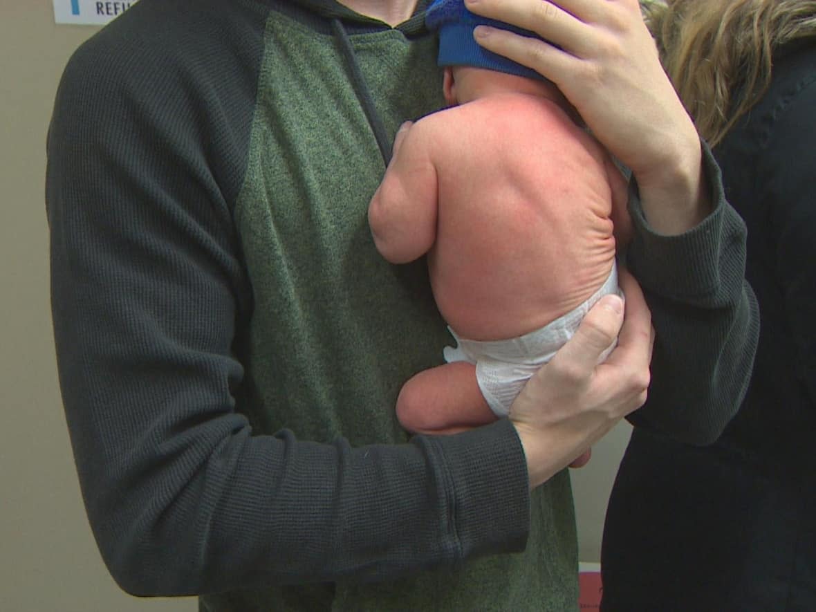 A parent holds a newborn at the mobile clinic on Mumford Road on Saturday.  (Jeorge Sadi/CBC - image credit)