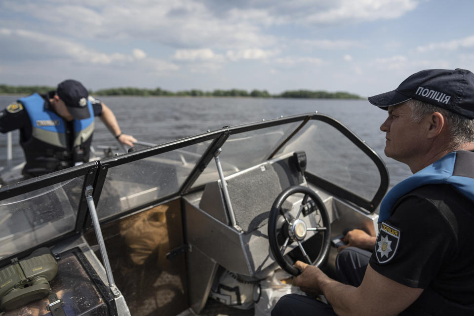 Police officers patrol area of Kakhovka reservoir on Dnipro river near Lysohirka, Ukraine, Thursday, May 18, 2023. Damage that has gone unrepaired for months at a Russian-occupied dam is causing dangerously high water levels along a reservoir in southern Ukraine. (AP Photo/Evgeniy Maloletka)