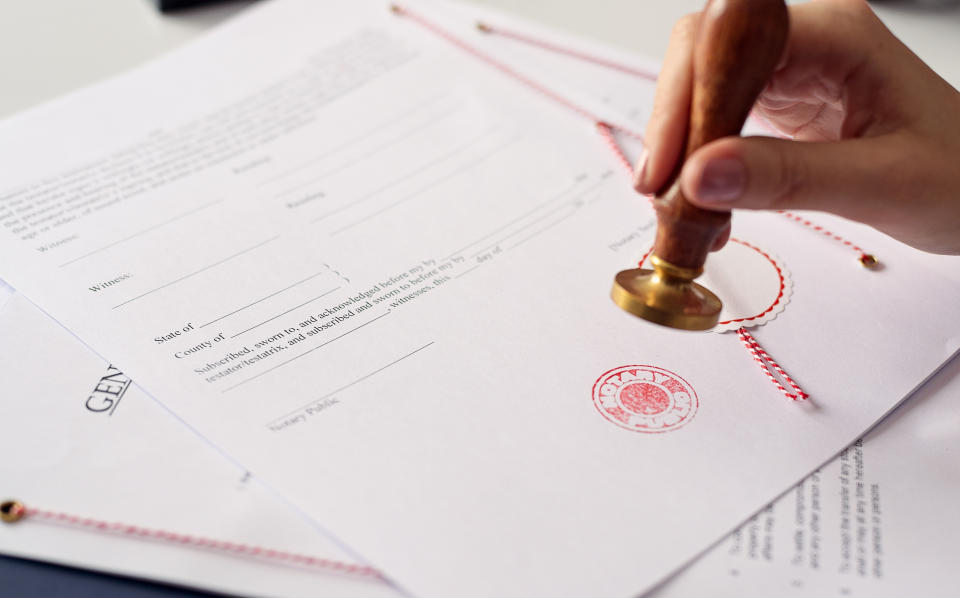 Close up on woman's notary public hand ink stamping the document. Notary public concept