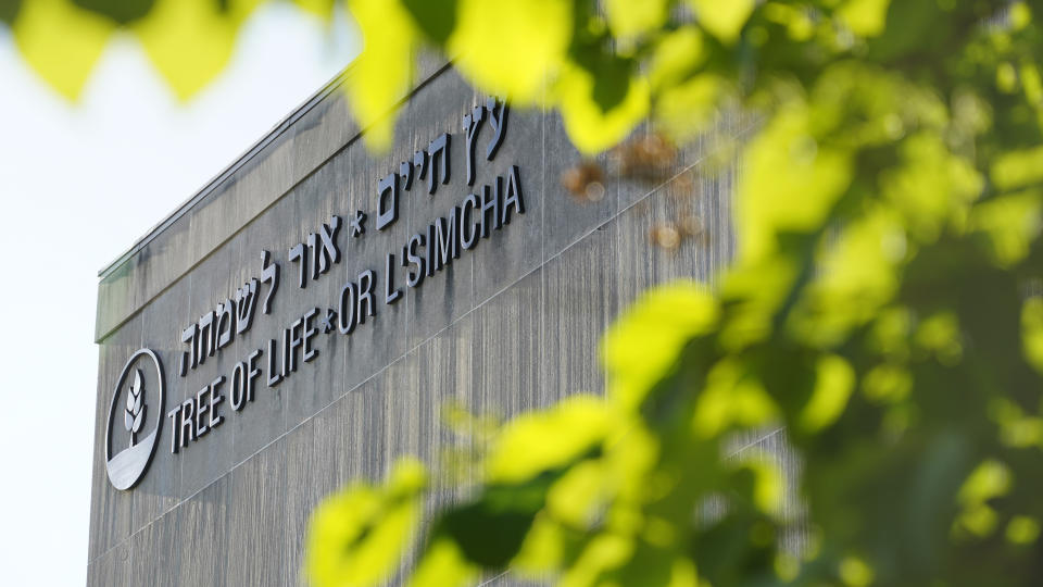 The signage on the dormant landmark Tree of Life synagogue in Pittsburgh's Squirrel Hill neighborhood is framed in spring foliage on Wednesday, April 19, 2023. The long-delayed capital murder trial of Robert Bowers in the 2018 Pittsburgh synagogue massacre will begin with jury selection beginning April 24, 2023, a federal judge has ruled. Bowers, a Baldwin resident who has pleaded not guilty, could be sentenced to death if convicted of the shootings. (AP Photo/Gene J. Puskar)