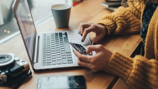 Woman in cafe shopping online with laptop.