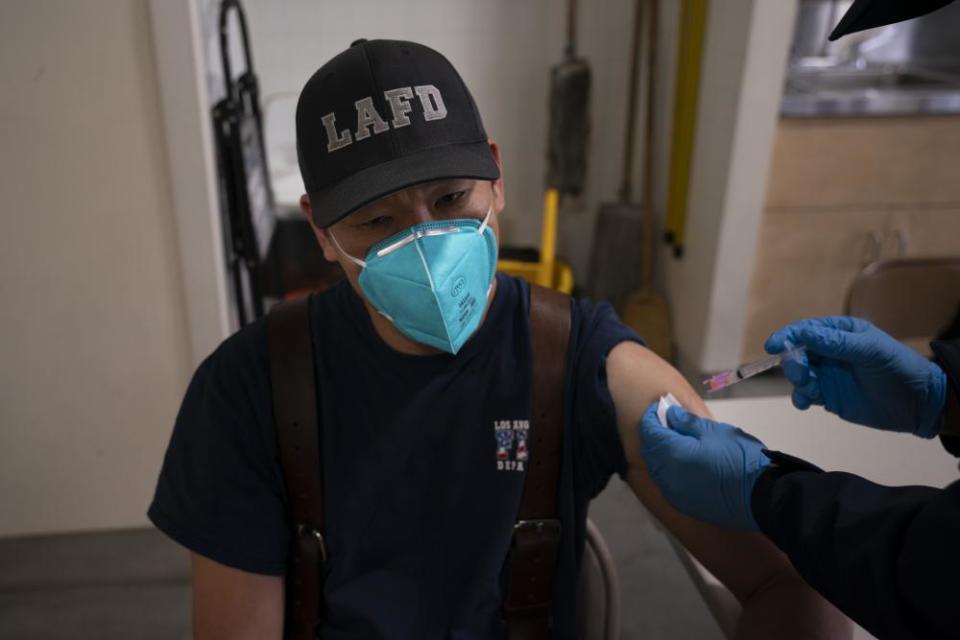 Henry Hsieh, a Los Angeles firefighter, receives his second dose of the Covid-19 vaccine at a fire station in Los Angeles.