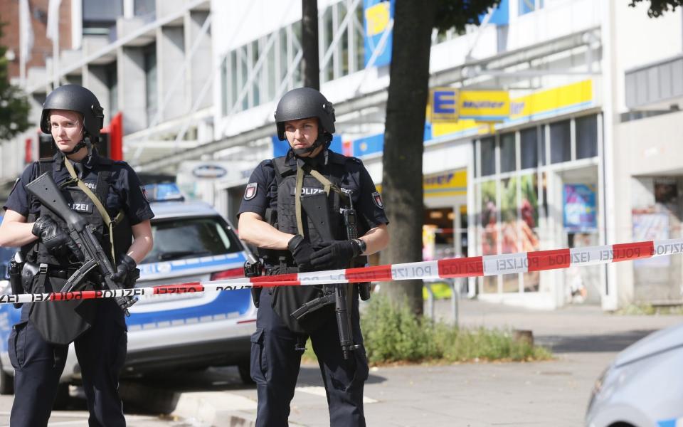 Police officers secure the area after a knife attack at a supermarket in Hamburg, Germany, Friday, July 28 - Credit: Paul Weidenbaum/AP