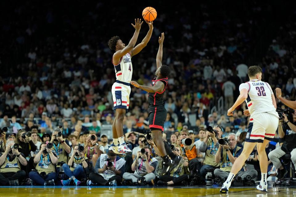 UConn guard Nahiem Alleyne shoots over San Diego State guard Darrion Trammell during the second half Monday night. It was the Huskies' fifth NCAA championship, tying them with Duke and Indiana for the fourth most won.