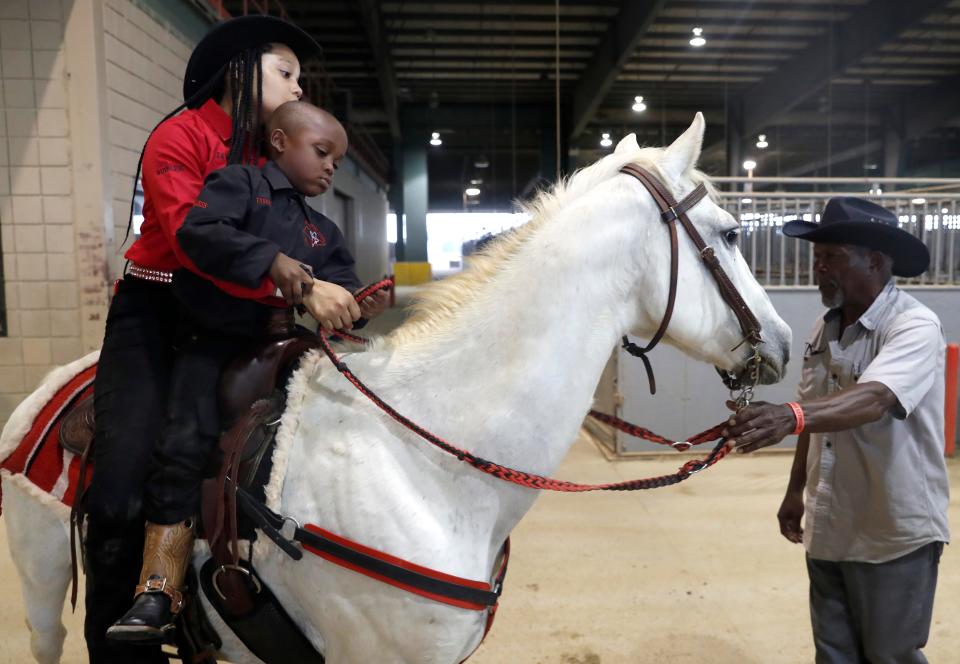 Tyson Brown, 4, sits on a horse with his big sister Jayde during the Southern Soul Black Invitational Rodeo on Saturday, May 21, 2022, at the Tunica Arena and Expo Center in Tunica, Miss. Black cowboys and girls participated in the event, which featured events such as barrel racing, mutton busting and calf roping. Their father, Tyrone Brown, is the president of Ruthless Ryderz, the organization that put on the event. 