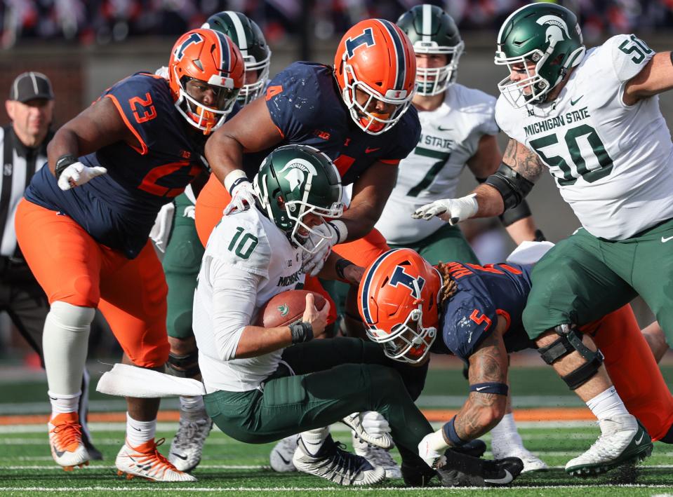 Jer'Zhan Newton (4) and Calvin Hart Jr. (5) of the Illinois Fighting Illini make the sack on Payton Thorne (10) of the Michigan State Spartans during the first half at Memorial Stadium on November 5, 2022 in Champaign, Illinois.