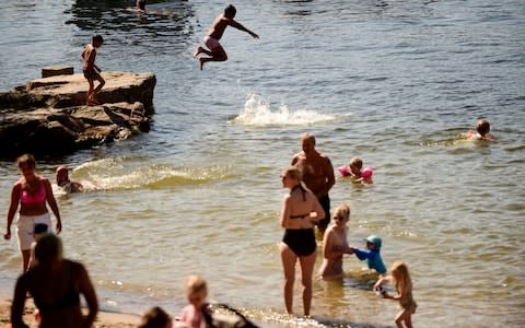 People bathe during a heatwave in Stockholm, Sweden - Credit: TT News Agency