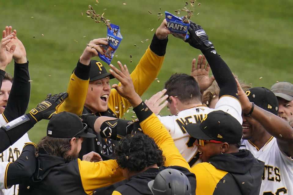 Pittsburgh Pirates' Kevin Newman, center right, celebrates with teammates after hitting the game-winning RBi single off Cincinnati Reds relief pitcher Alexis Diaz in the 10th inning of a baseball game in Pittsburgh, Wednesday, Sept. 28, 2022. The Pirates won 4-3 in 10 innings. (AP Photo/Gene J. Puskar)